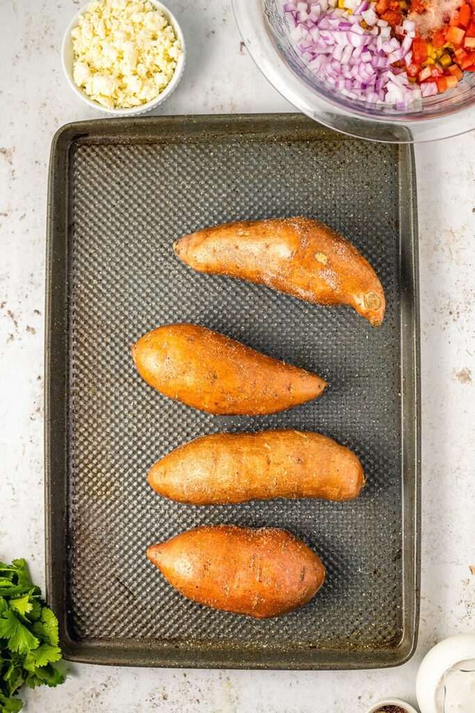 Baking whole sweet potatoes on a tray