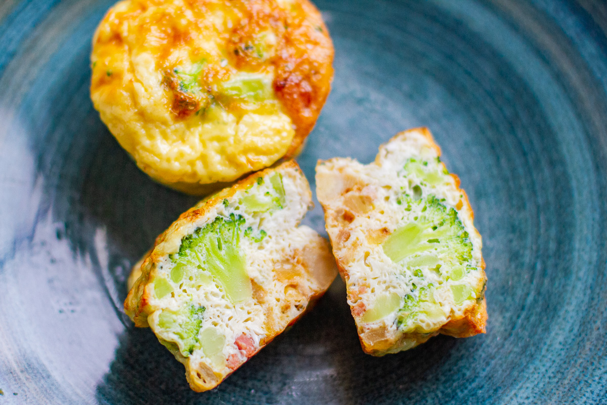 healthy egg muffins cut in half with broccoli and bacon inside